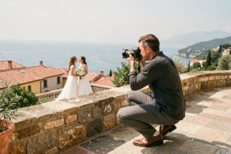 Photographe de mariage professionnel en action sur une terrasse en pierre avec vue sur la Méditerranée dans les Alpes-Maritimes