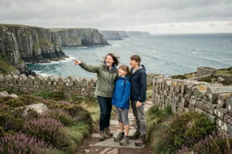 Famille en balade sur les sentiers côtiers de Bretagne avec vue sur les falaises de granit et l'océan Atlantique